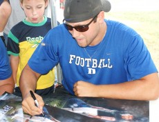 Brandon King signs a poster for a fan at the Durham Rescue Mission.